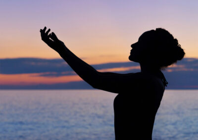 夕暮れの海辺でヨガをする女性 マインドフルネスとウェルビーイング